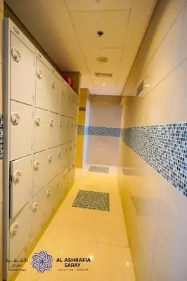 an empty locker room with a shower and a tiled floor at Alashrafia Saray- Homey 1BR apartment in Sport City in Dubai