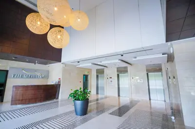 a lobby with a potted plant in a building at Alashrafia Saray- Homey 1BR apartment in Sport City in Dubai