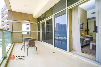 a room with a balcony with a table and chairs at Alashrafia Saray- Homey 1BR apartment in Sport City in Dubai
