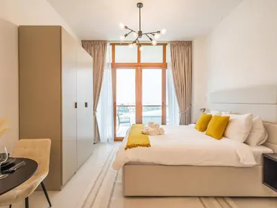 a bedroom with a large bed with yellow pillows at Paradise Studio in Palm Views - Palm Jumeirah in Dubai