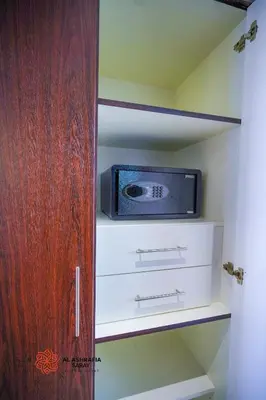 a small microwave sitting on a shelf in a closet at Alashrafia Saray- Superior 1BR apartment in Sport City in Dubai