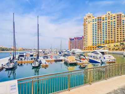 a group of boats docked in a marina with buildings at Minimalistic Studio in Palm Views - Palm Jumeirah in Dubai