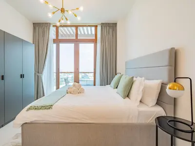 a bedroom with a large bed with a teddy bear on it at Minimalistic Studio in Palm Views - Palm Jumeirah in Dubai