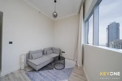 a living room with a couch and a large window at Chic Marina View Living in a Two Bedroom in Dubai