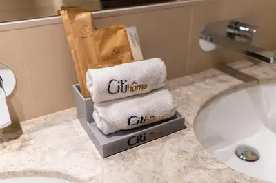 a pile of towels in a bathroom next to a sink at CitiHome- Modern- 1BR Creek Residence in Dubai