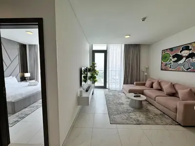 a living room with a couch and a bed at Panoramic 1br with Crystal Lagoon & Downtown View in Dubai