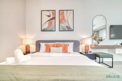 a bedroom with a large white bed and two mirrors at Picturesque Studio at Mesk 1 Midtown Dubai Production City by Deluxe Holiday Homes in Dubai