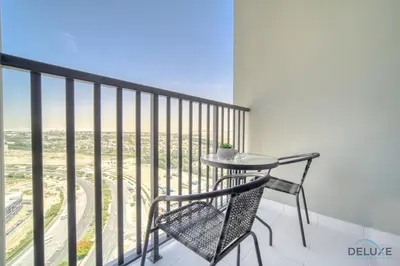 a table and chair on a balcony with a view at Picturesque Studio at Mesk 1 Midtown Dubai Production City by Deluxe Holiday Homes in Dubai
