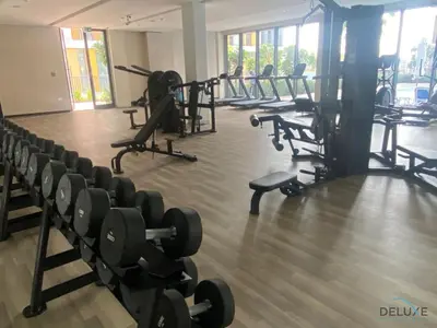 a gym with rows of chairs and weights at Graceful Studio at Mesk 1 Midtown Dubai Production City by Deluxe Holiday Homes in Dubai