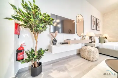 a bedroom with a bed and a tree in it at Classic Studio at Mesk 1 Midtown Dubai Production City by Deluxe Holiday Homes in Dubai