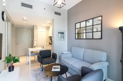 a living room with a couch and a table at CitiHome -1BR with Balcony & Pool View in Zada Tower in Dubai