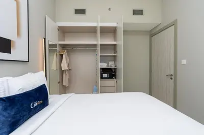 a bedroom with a white bed and a closet at CitiHome -1BR with Balcony & Pool View in Zada Tower in Dubai