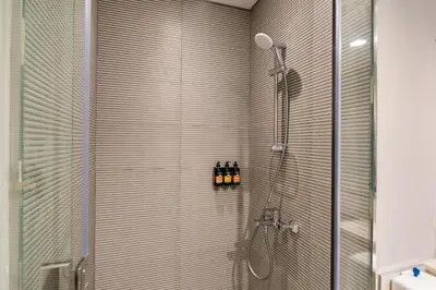 a bathroom with a shower with a glass door at CitiHome -1BR with Balcony & Pool View in Zada Tower in Dubai