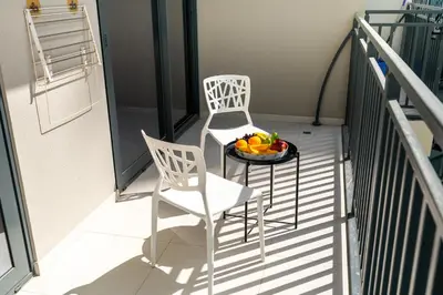a balcony with two chairs and a bowl of fruit on a table at CitiHome -1BR with Balcony & Pool View in Zada Tower in Dubai