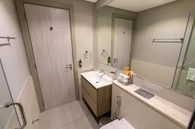 a bathroom with a sink and a shower with a mirror at CitiHome - Newly Furnished Apartment in Business Bay in Dubai