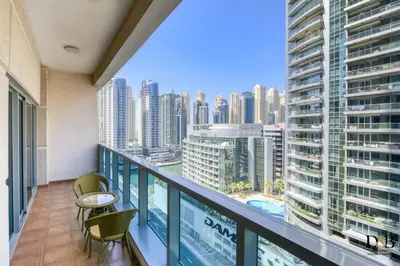 a balcony with chairs and a view of a city at Luxury 1 Bedroom Marina View, Sleeps 6, 1 Min to Metro in Dubai