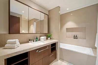 a bathroom with a sink and a tub and a mirror at Chic & Trendy 3BR+kid's in Vibrant Downtown Dubai in Dubai