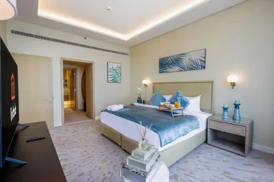 a bedroom with a large bed and a television at Livbnb - 1BR w/Spectacular Sea Views in Palm Tower in Dubai