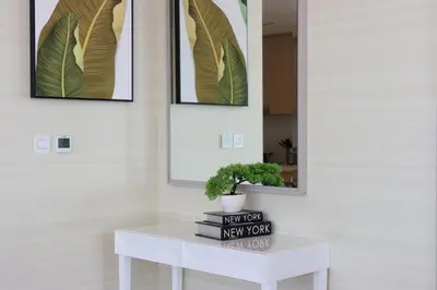 a white table with a plant on it next to two mirrors at Livbnb - 1BR w/Spectacular Sea Views in Palm Tower in Dubai