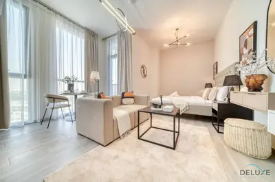 a living room with a couch and a table at Distinguished Studio at Mesk 1 Midtown Dubai Production City by Deluxe Holiday Homes in Dubai