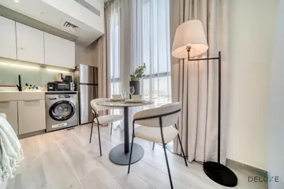a kitchen with a table and chairs in a room at Distinguished Studio at Mesk 1 Midtown Dubai Production City by Deluxe Holiday Homes in Dubai