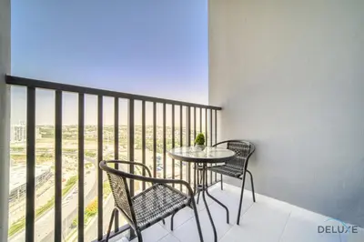 a table and chairs on a balcony with a view at Distinguished Studio at Mesk 1 Midtown Dubai Production City by Deluxe Holiday Homes in Dubai