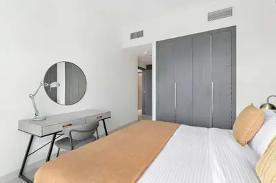 a bedroom with a bed and a desk and a mirror at Silkhaus luxurious 1BDR in AG Tower, Business Bay in Dubai