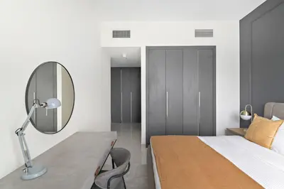 a bedroom with a bed and a desk with a mirror at Silkhaus luxurious 1BDR in AG Tower, Business Bay in Dubai