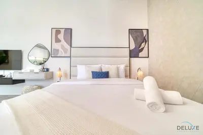 a white bedroom with two beds and a mirror at Incredible Studio at Mesk 1 Midtown Dubai Production City by Deluxe Holiday Homes in Dubai