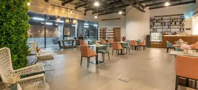 a restaurant with tables and chairs and plants at Pyramisa Hotel Apartments in Dubai