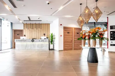a lobby with a reception desk and flowers in a building at Pyramisa Hotel Apartments in Dubai