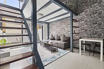 an open living room with a brick wall at ALiving Duplex Studio I Aria Residence by Grovy, JVC in Dubai