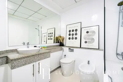 a white bathroom with a sink and a toilet at LUX The Dubai Marina View Suite in Dubai