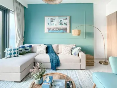 a living room with a white couch and blue walls at Trophy 2BDR Sandy Shores Retreat with Panoramic Sea View & Private Beach Access in Dubai