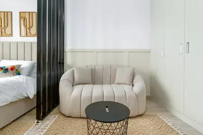a living room with a chair and a table at Cozy studio at Bloom Height - JVC in Dubai