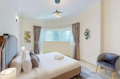 a bedroom with a bed and a chair and a window at Vacationer I Premium 3 Bedroom Apartment I Close to Marina Promenade & JBR Beach I Prime Location in Dubai