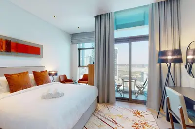 a bedroom with a large white bed and a balcony at 15 Northside - Chic Studio in Dubai