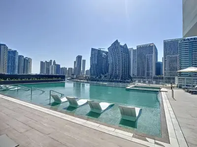 a swimming pool with chairs in the middle of a city at 15 Northside - Chic Studio in Dubai