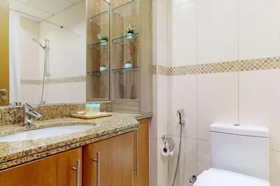 a bathroom with a toilet and a sink and a mirror at Saba Tower 3 - Elegant Studio Apartment in Dubai