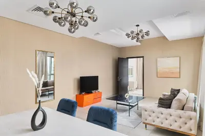a living room with a couch and a tv at BellaVista - Spectacular - 2 BR Penthouse - Boulevard Central - Panoramic Terrace & Burj Khalifa View in Dubai
