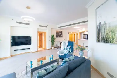 a living room with a couch and a tv at Dubai The Palm 4BR Beach & Pool Access in Dubai
