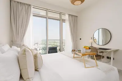 a bedroom with a white bed with a desk and a mirror at Maison Privee - Graceful Apt in Prestigious Dubai Hills close to the Golf Course in Dubai