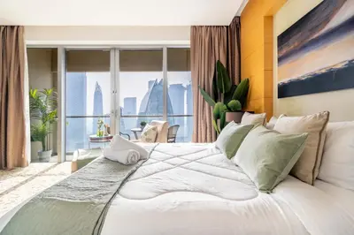 a bedroom with a large white bed with a large window at GuestReady - Fashion Avenue | Burj Khalifa View in Dubai