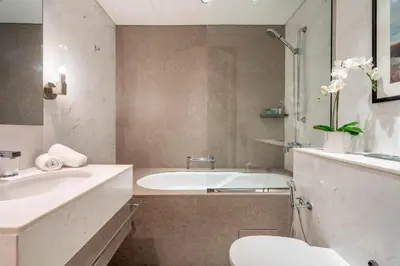 a bathroom with a tub and a toilet and a sink at GuestReady - Fashion Avenue | Burj Khalifa View in Dubai