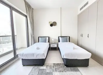 two beds in a room with a window at RH- Captivating Skyline View, 02BR Near Clemance Medical Center in Dubai