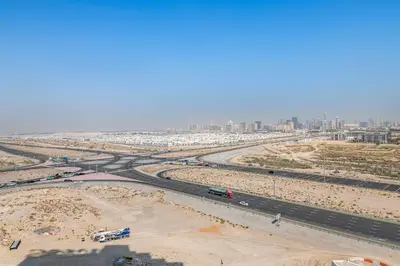 an aerial view of a highway with a city in the background at Luxurious - Studio - Damac Hills - Pool & Gym in Dubai