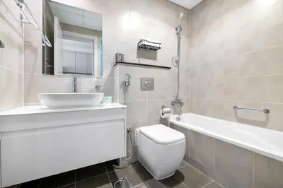 a bathroom with a sink and a toilet and a tub at Luxurious - Studio - Damac Hills - Pool & Gym in Dubai
