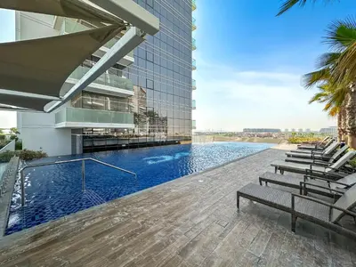 a swimming pool on the side of a building at Luxurious - Studio - Damac Hills - Pool & Gym in Dubai