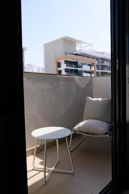 a chair and a table on a balcony at Mira Holiday Homes - Cozy studio in Meydan in Dubai