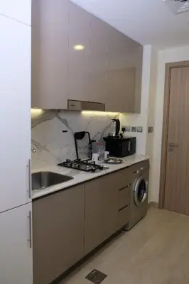 a kitchen with a sink and a stove at Mira Holiday Homes - Cozy studio in Meydan in Dubai